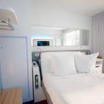 Bright modern bedroom with neatly made white bed and soft daylight, showing how to clean a mattress for better hygiene and fresh sleeping space